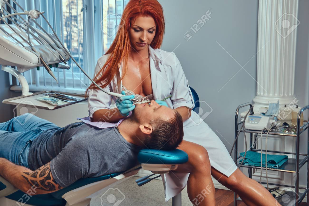 94100745-a-sexy-hot-redhead-dentist-woman-taking-care-of-her-patient.webp